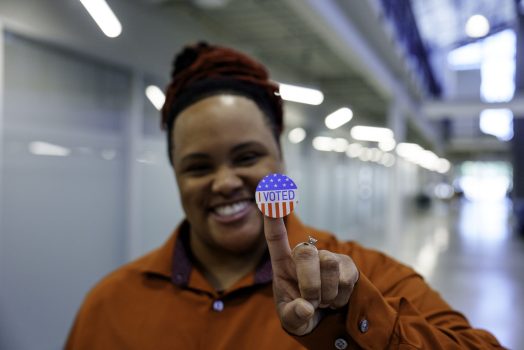 Young African American Plus Size Woman in a Co-working Space Smiling Proudly Wearing an I Voted Sticker Young African American Plus Size Woman in a Co-working Space Smiling Proudly Wearing an I Voted Sticker