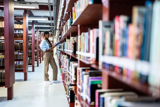 Young woman searching books in the library