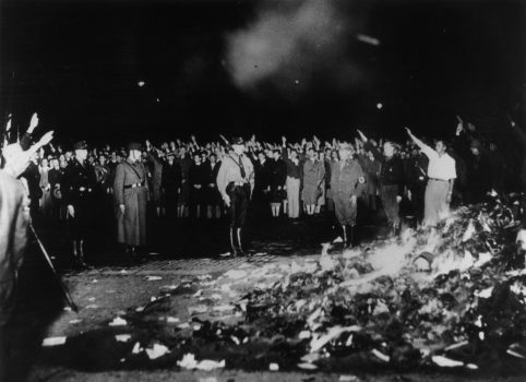 Book Burning May 1933: German soldiers and civilians give the Nazi salute as thousands of books smoulder during one of the mass book-burnings implemented throughout the country to destroy non-Aryan publications. (Photo by Keystone/Getty Images)