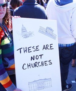 Victories-Shield Women holds pro church-state separation sign at rally.